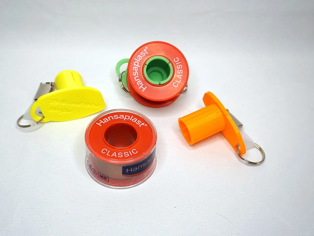 Abroller in Gelb, Grün und Orange mit Pflasterrolle